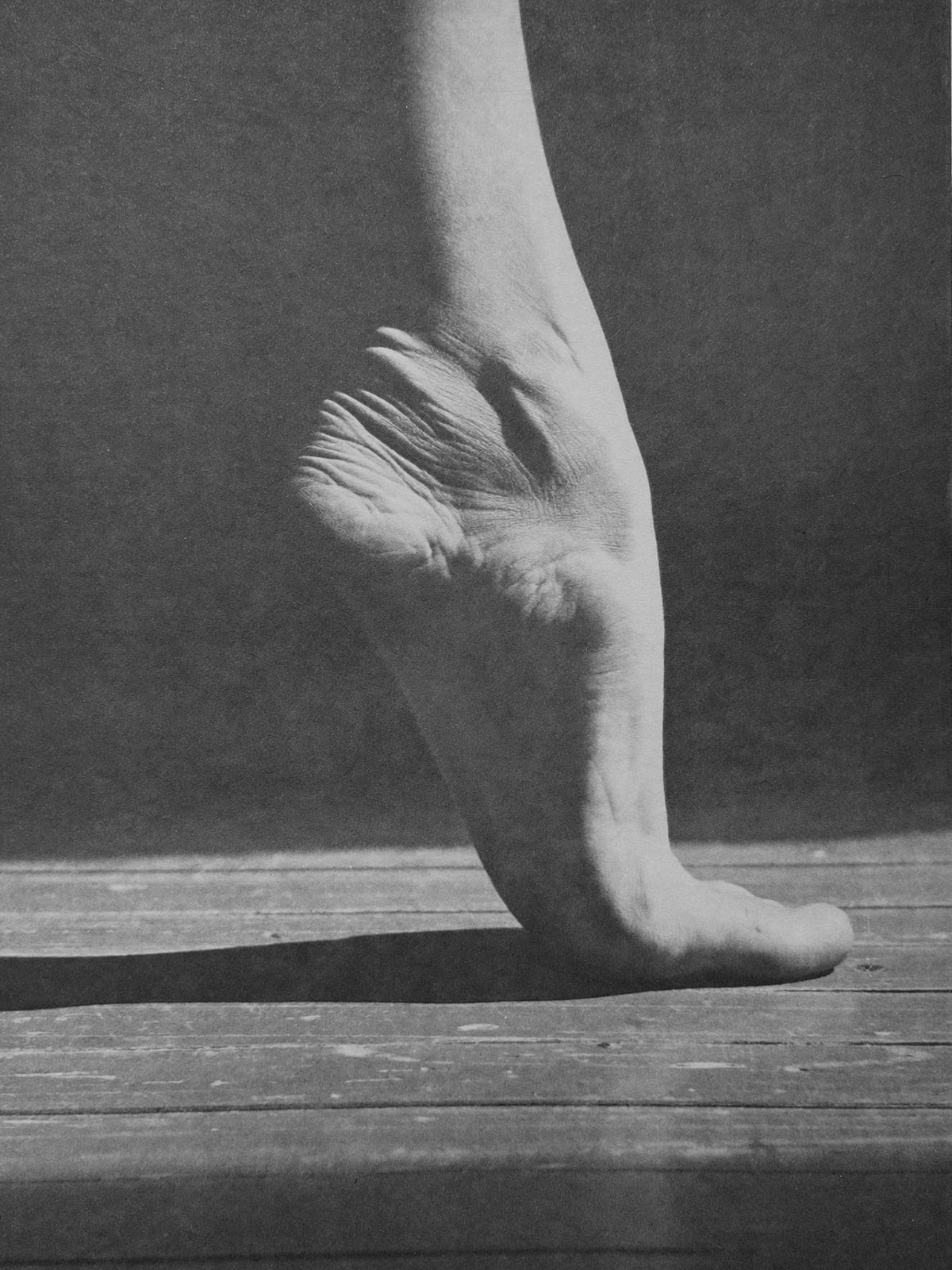 Pied nu trouvant son appui sur un vieux parquet